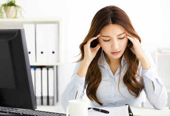 Portrait of tired young business woman working in office