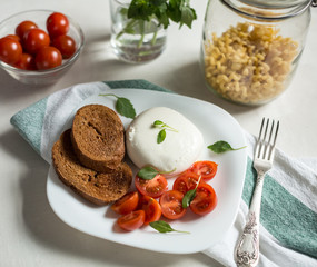 Plate of Caprese Salad with Mozzarella Cheese, Tomatoes, Basil a