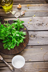 Fresh basil on wooden chopping board and olive oil on the table.
