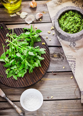 Pesto and ingredients on wooden table.