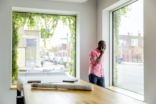 African American businessman talking on cell phone in office