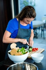 woman preparing sliced vegetables for dinner