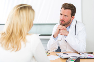 Obraz premium Young attractive doctor listening his patient