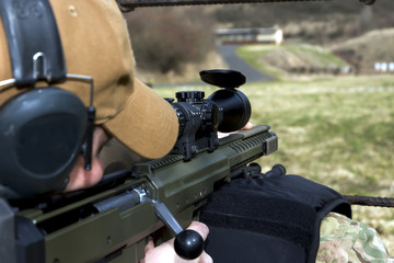 Military sniper aims at a target