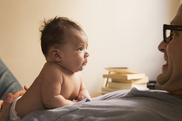 Smiling father playing with baby
