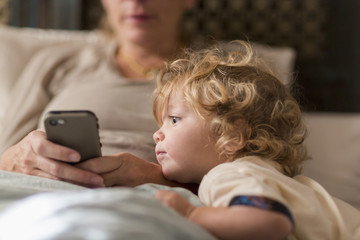 Caucasian mother and son playing with cell phone