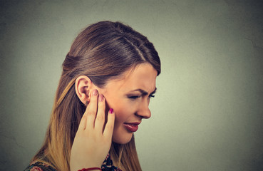 Tinnitus. Closeup side profile sick young woman having ear pain touching her painful head