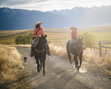 Caucasian mother and son riding horses on ranch