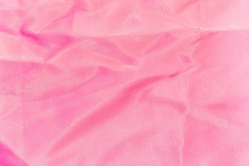 background, texture of crumpled pink silk fabric
