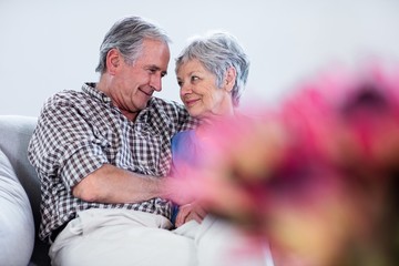 Happy senior couple embracing each other on sofa