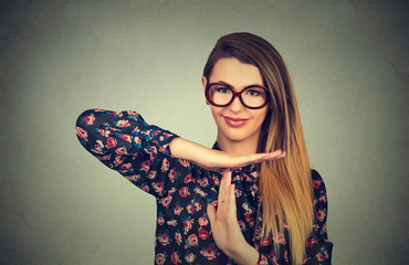 young, happy, smiling woman showing time out gesture with hands