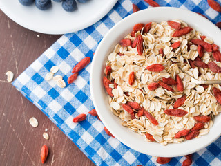 Bowl with oats and goji berries for breakfast to be eaten with smoothie or yogurt