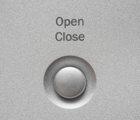 Macro of Open, Close button on aluminum panel.