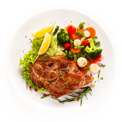 Grilled steak and vegetables on white background