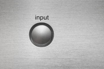 Macro of Input button on aluminum panel.