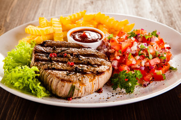Grilled steak, French fries and vegetables 