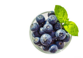 Upper view on blueberries in glass with leaves of mint 