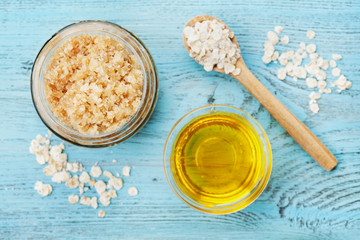 Body scrub of oatmeal, sugar, honey and oil in glass jar on blue rustic table, homemade cosmetic...