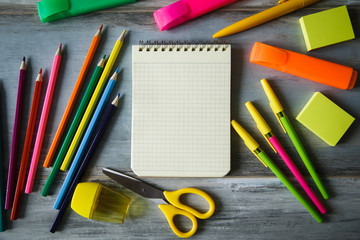 Bright stationery objects and the notebook on wooden table copy space close up