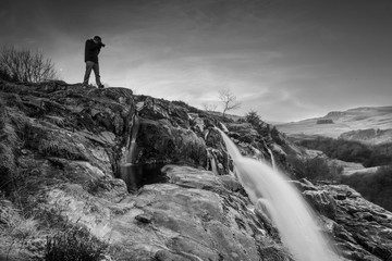 Obraz premium Photographer shooting into the Loup of Fintry Waterfall