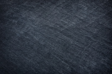 Dark grey / black slate background or texture.