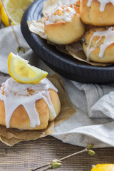 Cinnamon rolls with lemon glaze in wooden plate
