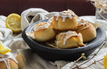 Cinnamon rolls with lemon glaze in wooden plate
