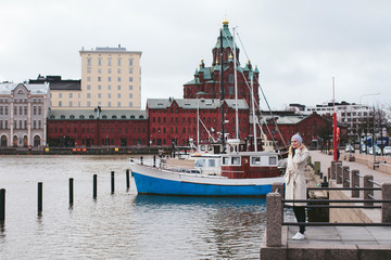 girl standing on the pier among ships and views of the city