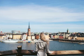 Fotobehang girl is standing back with a view of the city of Stockholm © stock.film