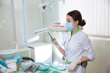 Dentist woman with medical instruments in the dental office doing procedures