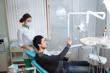 Doctor and her patient doing photo selfie in dental office