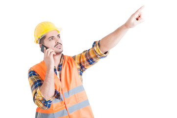 Attractive engineer pointing finger upwards while using cellphon