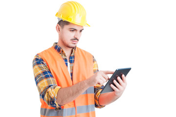Young constructor working on touch pad device or tablet