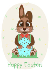 Kind and cute brown Easter rabbit is sitting in the grass with decorated Easter egg in his paws