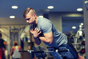 Fototapeta na wymiar young man flexing back muscles on bench in gym