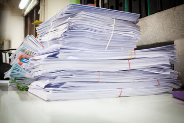 Stack of business report paper files with black clips