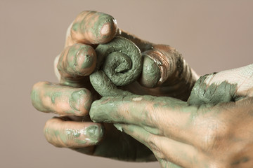 closeup of hands molding from clay