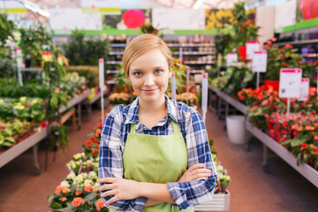 happy woman with flowers in greenhouse