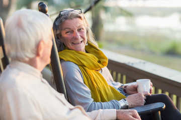 Older Caucasian couple drinking coffee on porch