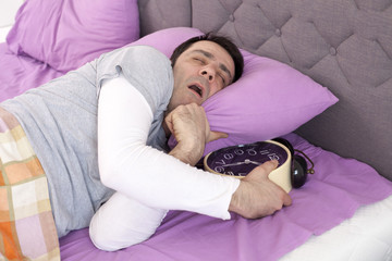 Man turning off the alarm clock
