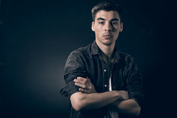 Porträt von einem Jugendlichen auf einem dunkelen Hintergrund 