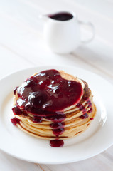 Light breakfast. Fresh pancakes on white plate with berry jam