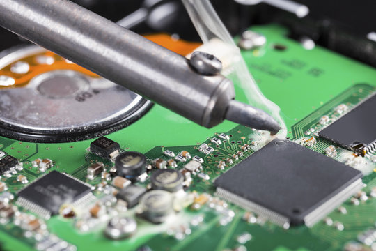 macro shot of soldering iron and circuit board