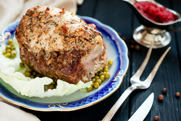 
meat , home baked ham or 
cold boiled pork with spices , lettuce, green peas and sweet and sour berry sauce on a wooden background