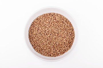 Bowl of buckwheat grains on white background