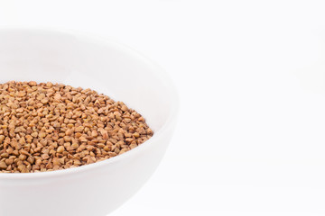 Buckwheat in a bowl on a white background