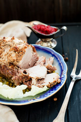 
meat , home baked ham or 
cold boiled pork with spices , lettuce, green peas and sweet and sour berry sauce on a wooden background