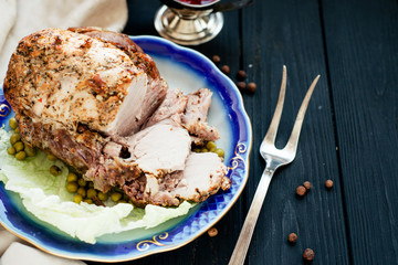 
meat , home baked ham or 
cold boiled pork with spices , lettuce, green peas and sweet and sour berry sauce on a wooden background