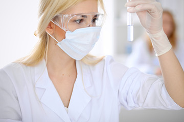 Naklejka premium Female scientific research team with clear solution in laboratory