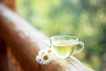 Cup of herbal tea on the railing of the balcony.